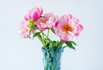 Beautiful peonies flowers in a vase on a light background. Postcard
