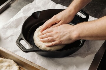 Hands pressing dough into a pan