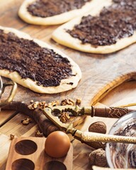 Several Lebanese manouche are topped with zaatar, next to an egg, walnuts, and a nutcracker. The...