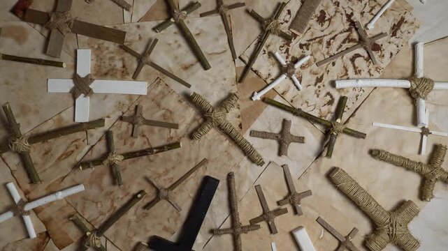 Wooden crucifixes cross on the ancient parchment paper. Handmade religion Christ crosses items made of forest twigs and sticks. Jesus Christ son of God prayer on old weathered burnt textured paper.