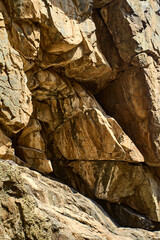Close-up of sandstone or volcanic tuff rock with cracks, natural relief, and mineral details,...