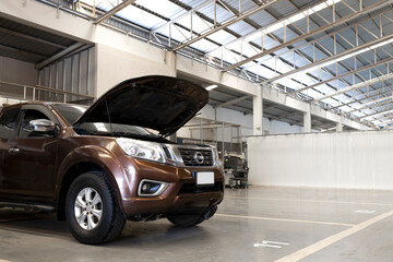 car with open hood inside a clean and modern auto repair workshop