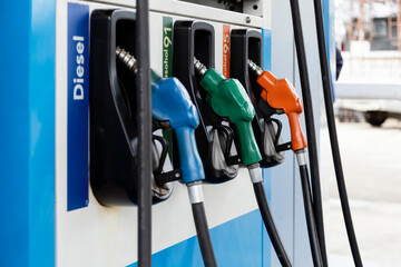 Colorful fuel nozzles at gas station for diesel and gasoline types