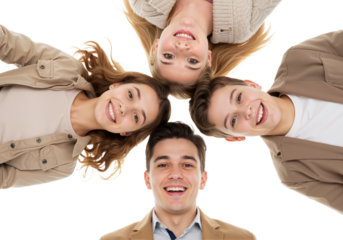 A cheerful group of four young friends looking down in a huddle, smiling together in a circle to show unity and happiness.