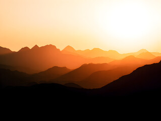Fototapeta premium Golden sunset casts a warm glow over layers of majestic mountain peaks, creating a stunning vista