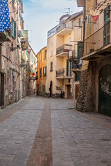 Fototapeta premium Medieval houses in Albenga, characterized by narrow alleys called carrugi, and arches, support bridges between the houses in the historic center, in the province of Savona, Liguria.