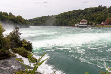 An impressive panoramic view of the Rhine river near the Rhine Falls, with a wide area of foamy...