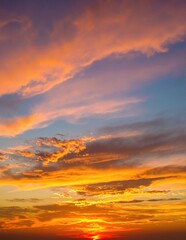 Fototapeta premium A breathtaking sunset paints the sky in vibrant hues of orange, pink, and purple, with fluffy clouds softly illuminated by the fading light.