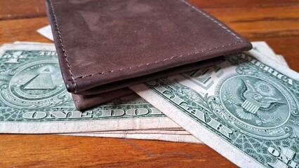 Leather wallet and dollar bills