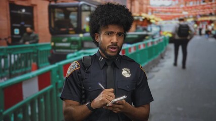Police officer writing notes at a busy construction site outdoors, wearing a badge and uniform, surrounded by urban scenes, barriers, and machinery in the background.