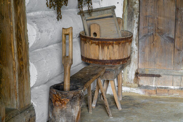 Antique laundry equipment with a wooden washtub, washboard, and beetle, placed against the wall of...