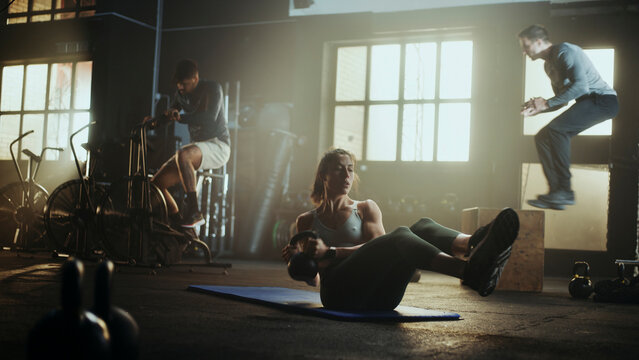 Athletes training together in crossfit gym: performing various exercises