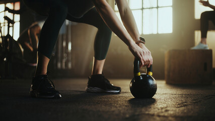 Woman picking up kettlebell during cross training workout