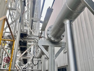 Industrial steel pipelines and structural framework in a processing plant, showcasing modern...