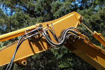 close-up of the boom and stick of a hydraulic excavator, highlighting the hydraulic lines and cylinders that power its movements. construction industry design element © mailcaroline