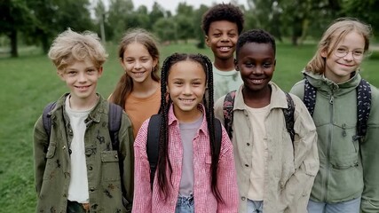 A happy and diverse group of school children with backpacks walking together in a park, a scene embodying childhood friendship, multicultural unity and inclusive education - Powered by Adobe