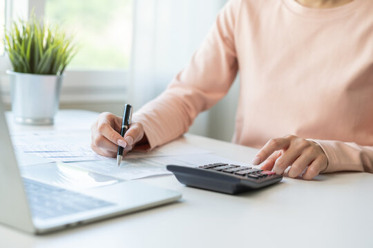 Deduction planning, debt asian young woman  hand using calculator to calculating  money balance from bill and income, cost budget expenses for pay money form personal individual on table at home.