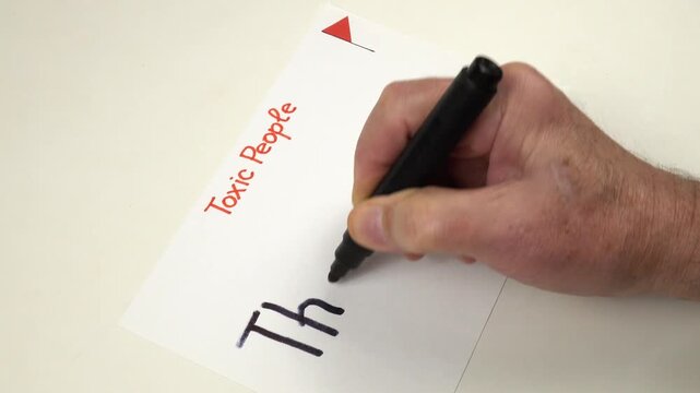 Person writes by hand The Gossiper on a sheet of paper.  Preparation to the psychotherapy training on the topic of Toxic people