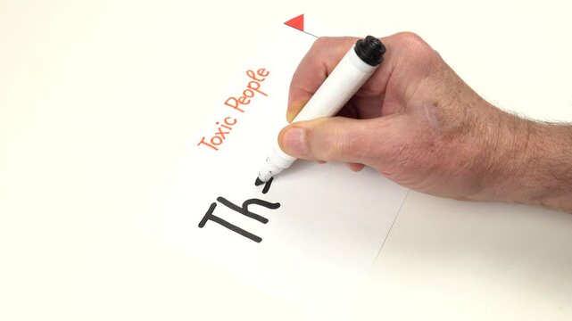 Person writes by hand The Strait Jacket on a sheet of paper.  Preparation to the psychotherapy training on the topic of Toxic people