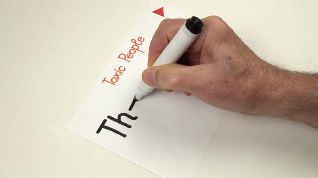 Person writes by hand The Conversational Narcissist on a sheet of paper.  Preparation to the psychotherapy training on the topic of Toxic people