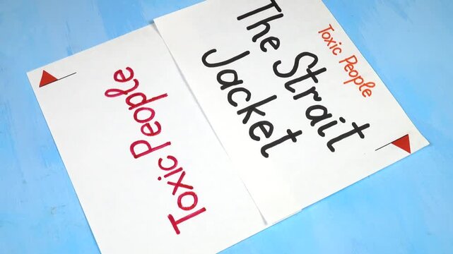 Words &ldquo;The Strait Jacket&rdquo; handwritten on a white sheet of paper. Sheets of paper with written theses on the topic &laquo;Toxic People&raquo; are on a blue background 