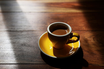 Small yellow coffee cup under sunlight