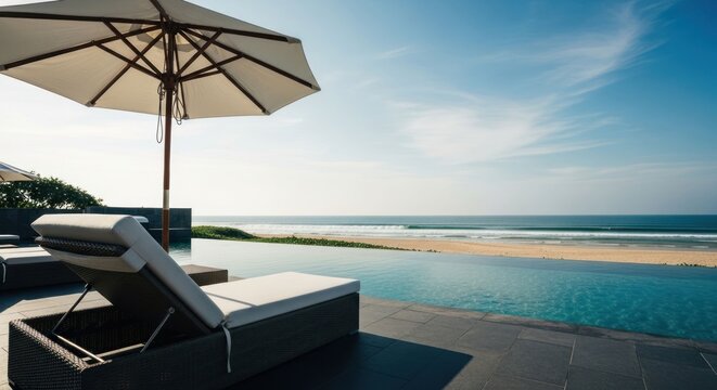 Ocean view from pool with umbrella and lounge chairs on sunny day
