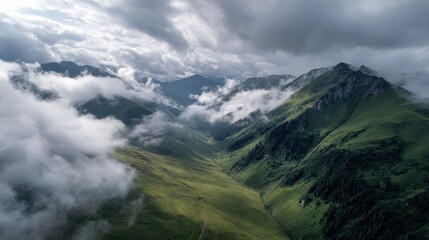Dramatic aerial view of mountain peaks piercing through low lying clouds during the daytime