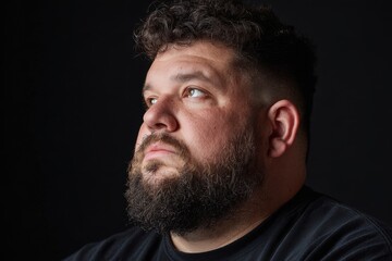 Fototapeta premium Portrait of a heavyset man against a black background
