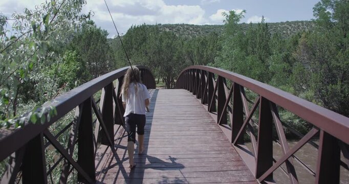 Little Girl Walking Over a Bidge With Fishing Pole