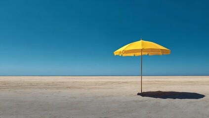 Yellow beach umbrella casting shadow on sandy shore of an empty blue ocean beach under clear sunny skies, panoramic view highlighting the vastness and tranquility of nature
