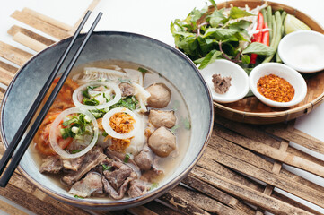 Overhead View of Savory Beef Noodle Soup with Fresh Herbs and Spices
