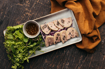Overhead View of Sliced Meat Dish with Dark Sauce and Herbs