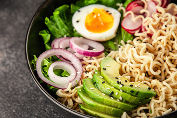 Vegetarian noodle bowl avocado, noodles, egg, vegetables tasty snack fresh delicious gourmet food background on the table rustic food top view copy space keto and paleo diet vegetarian food