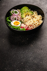 Vegetarian noodle bowl avocado, noodles, egg, vegetables tasty snack fresh delicious gourmet food background on the table rustic food top view copy space keto and paleo diet vegetarian food