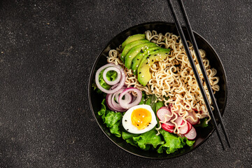 Vegetarian noodle bowl avocado, noodles, egg, vegetables tasty snack fresh delicious gourmet food background on the table rustic food top view copy space keto and paleo diet vegetarian food