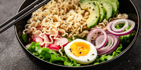Vegetarian noodle bowl avocado, noodles, egg, vegetables tasty snack fresh delicious gourmet food background on the table rustic food top view copy space keto and paleo diet vegetarian food