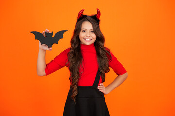 All Hallows devil. Imp horns. Girl in Halloween imp costume hold bat. Happy Halloween. Girl devil...
