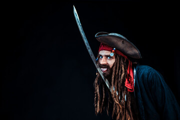 Playful pirate with sword and tongue out on black background
