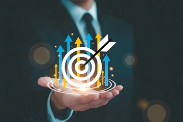 Businessman holding goal target with arrow hitting center indicating business achievement