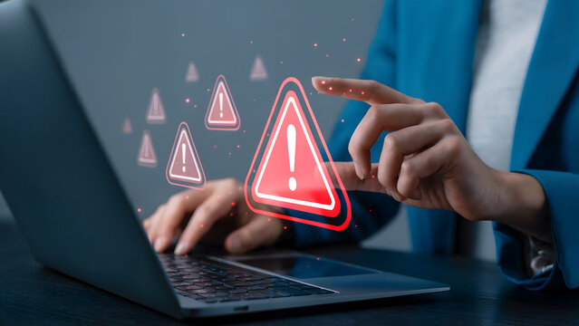 Alert woman touching virtual warning sign on laptop screen for cybersecurity notification or error message, emphasizing system vulnerability and data breach risks