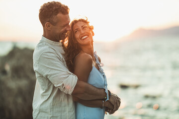 Fototapeta premium Couple In A Hug Enjoying A Sunset At The Beach
