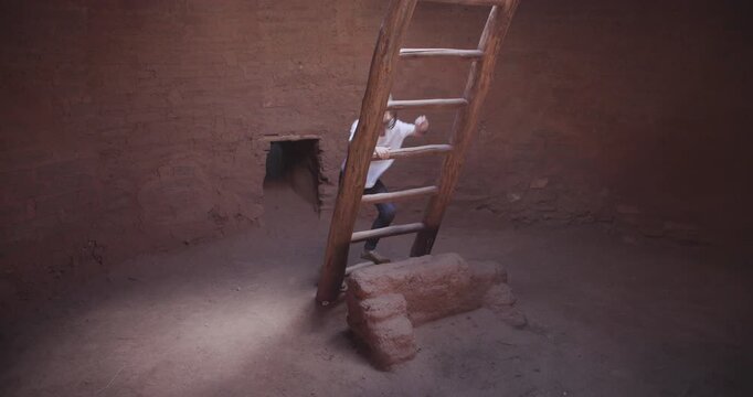Kid Climbing Up Historic Pueblo Ladder