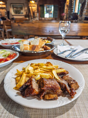 Dining in a Croatian konoba. The focus is on a delicious plate of roasted meat, showcasing the rich flavors of Mediterranean cuisine.A satisfying meal in Croatia