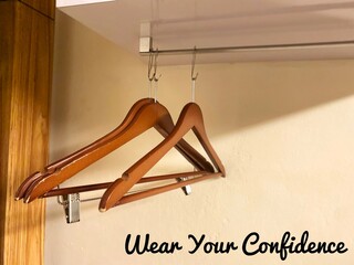 Three empty wooden hangers with the motivational quote, 