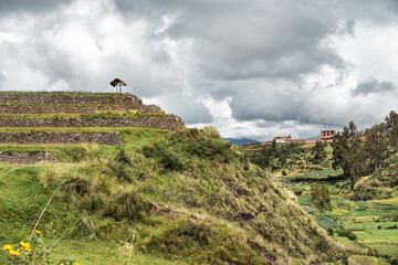 Ancient Inca stone terraces at the archaeological site of Chinchero, Peru against misty Andean mountains