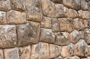 A detailed view of the precisely fitted stones forming an ancient Inca wall at the archaeological site of Chinchero, Peru.