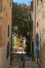 Picturesque narrow alleyway in the old city of Jaffa, Israel, with traditional stone buildings and...