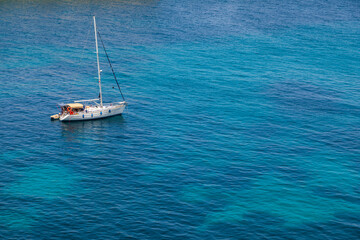 Sailboat anchored in turquoise waters near St. Peters Pool, Malta.