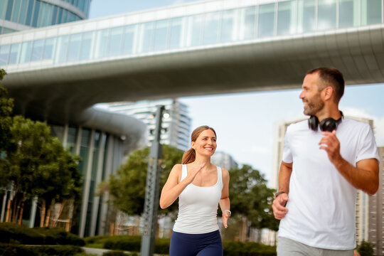 Joyful morning joggers enjoying an active day in a vibrant urban park beneath modern architecture - Powered by Adobe